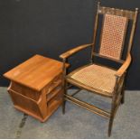 A 1920s oak open arm chair canework back and seat; an oak occasional table/cantebury (2)