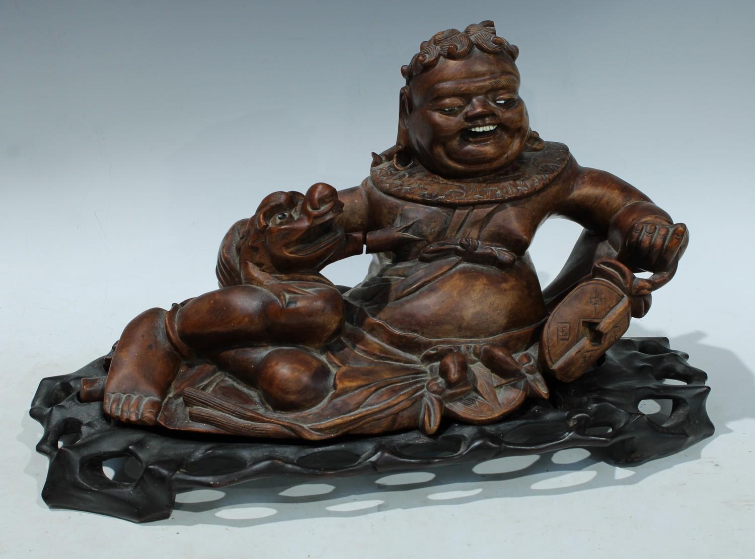 A Chinese hardwood figure, carved as Liu Hai and a three legged toad, carved and pierced base,
