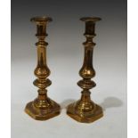 A pair of 19th century brass ejector candlesticks, reel shaped sconces, canted square bases, 31cm