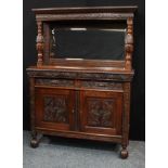 A late Victorian oak mirror back sideboard, outswept cornice above a frieze carved with leafy