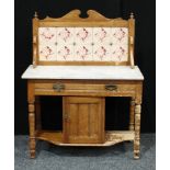A Victorian pine washstand, swan neck pediment above floral tiles, marble top, one long drawer and a