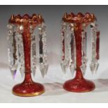 A pair of 19th century ruby glass lustres, gilded scrolling decoration, clear faceted drops, each
