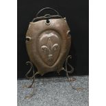 An art nouveau copper and wrought iron shield shaped fire guard, embossed with a fleur-de-lis,