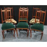 A set of four Arts and Crafts mahogany dining chairs, the backs pierced and shaped in the Art