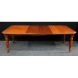 A mid 20th century mahogany extending dining table, canted rectangular top above a deep frieze,