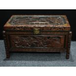 A Chinese inspired brass mounted hardwood blanket chest, profusely carved throughout with warriors