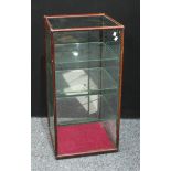 A counter top mahogany shop display cabinet, square top above a glazed door inclosing adjustable