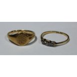 An 18ct gold and three stone diamond ring; an 18ct gold signt ring