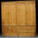 A substantial country house pine housekeepers cupboard, outswept cornice above four cupboard doors