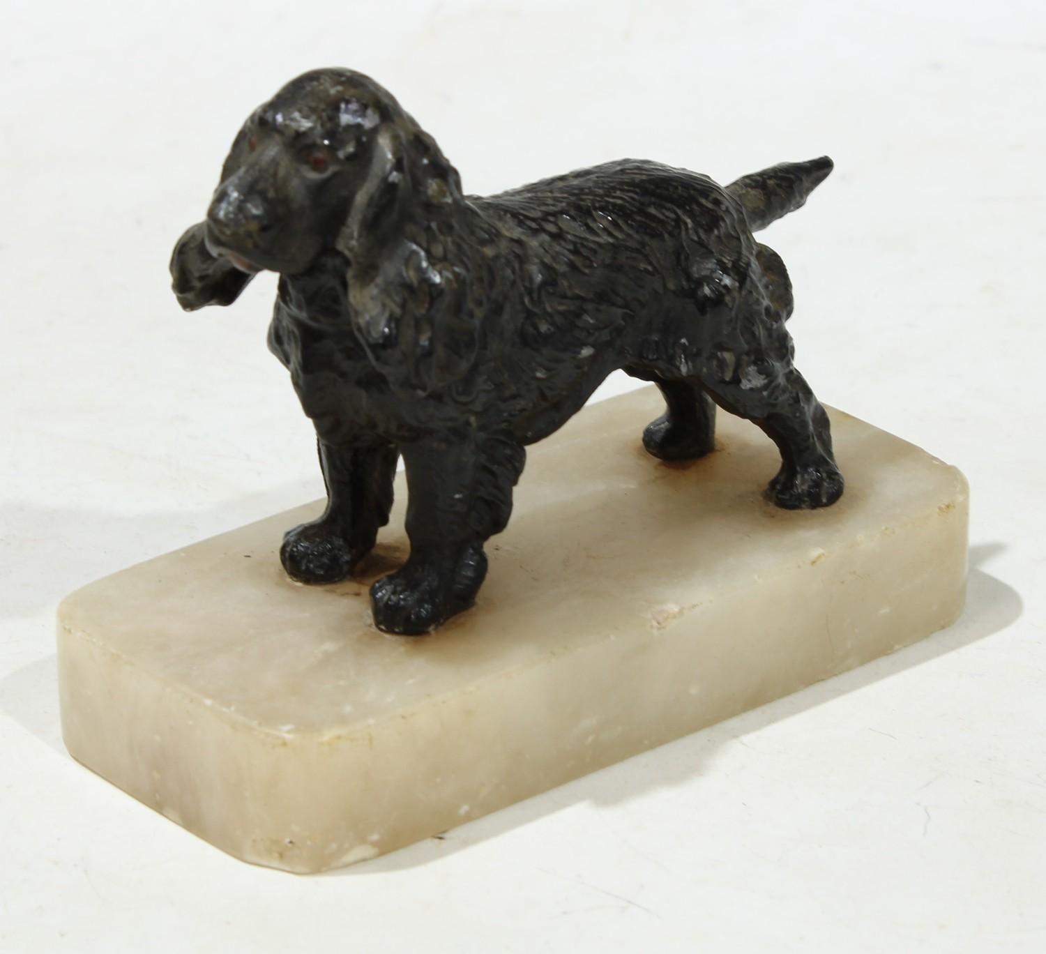 An early 20th century painted model of a spaniel, rectangular alabaster base, 12cm wide c.1920.