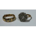An 18ct gold and diamond cluster ring, 3.6g; an 18ct gold diamond three stone ring, 4.4g (2)