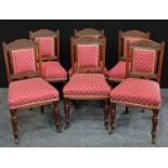 A set of six Victorian walnut dining chairs, carved back, stuffed over upholstery, turned legs.(6)