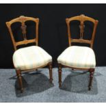 A pair of Edwardian mahogany dining/side chairs, stuffed over upholstery, turned legs, 86cm high (2)