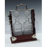 A mahogany two bottle tantalus, silver plated handle and mounts, 34cm high, 25cm wide