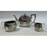 A Walker and Hall three piece EPNS tea service, embossed with foliate scrolls, angular handles,