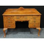 A Queen Anne style mahogany knee hole desk, shaped half gallery, oversailing rectangular top above