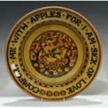 A large studio pottery charger, slip glazed, painted with the motto, Comfort Me With Apples For I Am