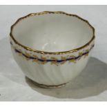 An 18th century Derby tea bowl, spirally fluted and decorated with cobalt blue band and gilt