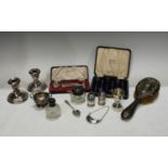 A cased set of six hallmarked silver teaspoons; a pair of hallmarked silver boudoir candlesticks;