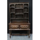 A mid 20th century oak dresser, moulded outswept cornice above plate racks, projecting base with a