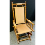 An early 20th century American bobbin turned rocking chair, upholstered back and seat panel, c.1920