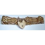 A 9ct rose gold four bar gate bracelet, engraved & chased heart shaped padlock 16.6g