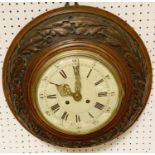 A Victorian oak wall clock, Roman numerals, twin winding holes, the case carved overall with