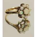 A 9ct gold opal flower head cluster ring central cabochon opal surrounded by eight smaller panels,
