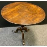 An 18th century oak tilt top table, circular top with bird cage type fittings, turned column, tripod