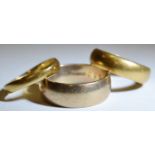A 22ct gold half barrel wedding band, size Q, 7.4g; another 9ct, size T1/2 7.9g; a yellow metal,