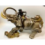 A retro hollow cast model, tribesmen riding an elephant being attacked by a pair of tigers, 35.5cm