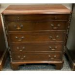 A mahogany bachelors chest, moulded top, canted angles carved in relief, brushing slide over four