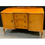 A 1950?s sideboard, inverted breakfront, three drawers flanked by cupboards, cabriole legs, pad