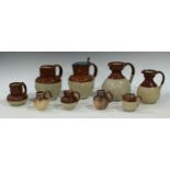 A collection of glazed stoneware jugs, some commemorative; others including a Denby brown salt