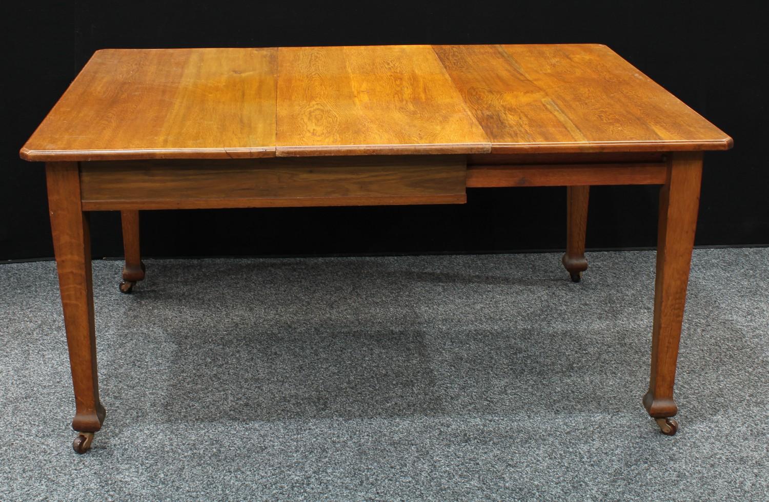 An Arts and Crafts oak extending dining table, tapered square legs, extending to 150cm wide.