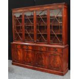 A large George III style mahogany library bookcase, dentil cornice above four glazed doors enclosing