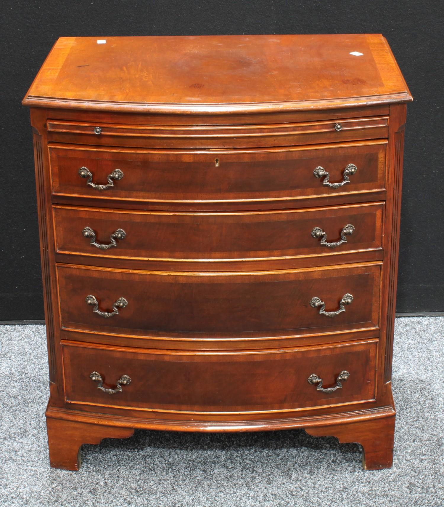 A George III style crossbanded mahogany bow fronted bachelor?s chest, brushing slide above four