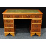 A yew wood twin pedestal desk, rectangular top with inset writing surface above three frieze
