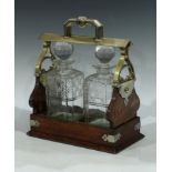 An Edwardian oak tantalus, comprising two cut glass decanters with stoppers, with key