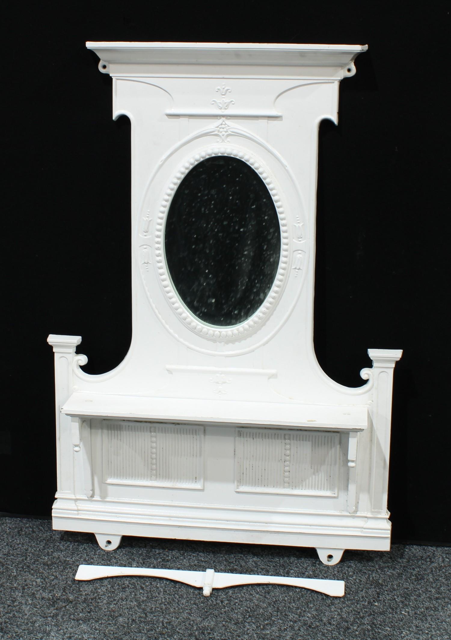 A 'Victorian' cast iron chimney piece, the painted superstructure with an oval mirror plate above