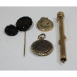 A yellow metal retractible pencil, unmarked; a lava cameo brooch; a jet stick pin; a mourning locket