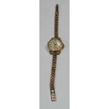 An 18ct gold lady's Orlux wristwatch with 9ct gold bracelet strap, champagne dial, Arabic