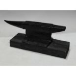 An anvil, wooden plinth base, 39cm wide, 15cm high