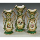 A garniture of three Rockingham type two handled slender baluster vases, the central catouches