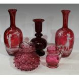 A pair of Mary Gregory style cranberry glass vases, each decorated with children, each 23cm high;