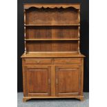 A 20th century oak dresser, outswept cornice above plate racks, the projecting rectangular base
