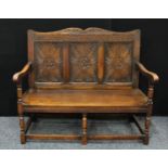 A 17th century style oak bench/settle, shaped cresting rail carved with acanthus, above a three