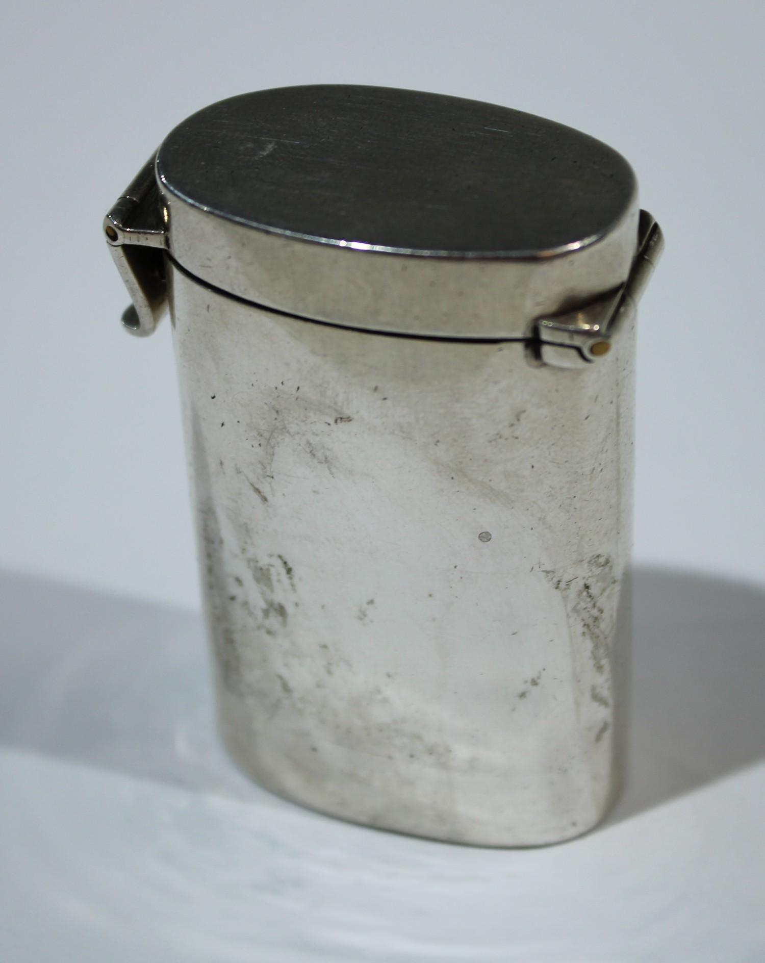 An unusual George V silver oval vesta case, hinged cover fastened with a bold clasp, striker to