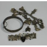 A silver charm bracelet with assorted silver and plated charms; a silver hinged bangle; a silver