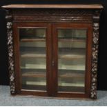 A late Victorian oak library bookcase upper stage, rounded cornice above a pair of glazed doors